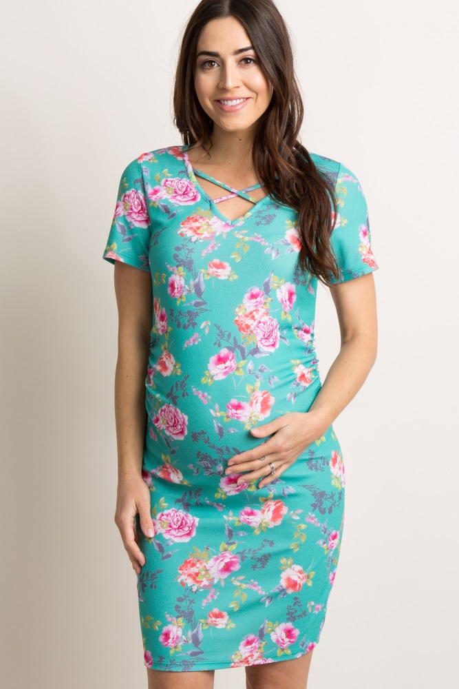 A floral short sleeve fitted maternity dress. V-neckline with crisscross accent. Ruched sides.